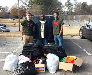 Kappa Sigma pose with clothing donations