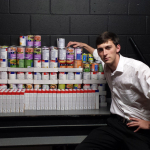 Fraternity member sits with donated pantry staples.