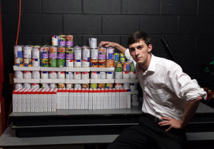 Fraternity member sits with donated pantry staples.