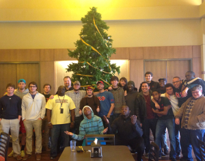 Fraternity brothers in front of a large Christmas tree.