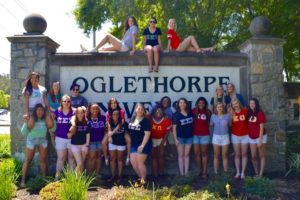 Members from sororities gather on and around the Oglethorpe University sign.