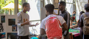 A member of Alpha Phi Alpha talks to prospective recruits in TLCC.